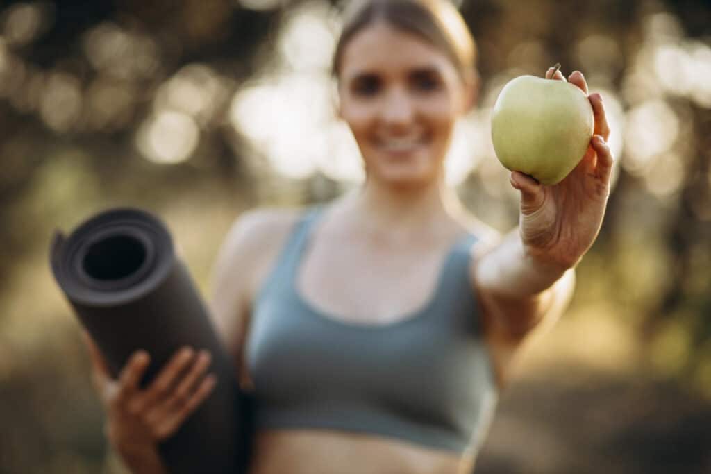 Retatrutide témájú egészséges lifestyle kép almával, jóga matraccal és szabadtéri edzéssel